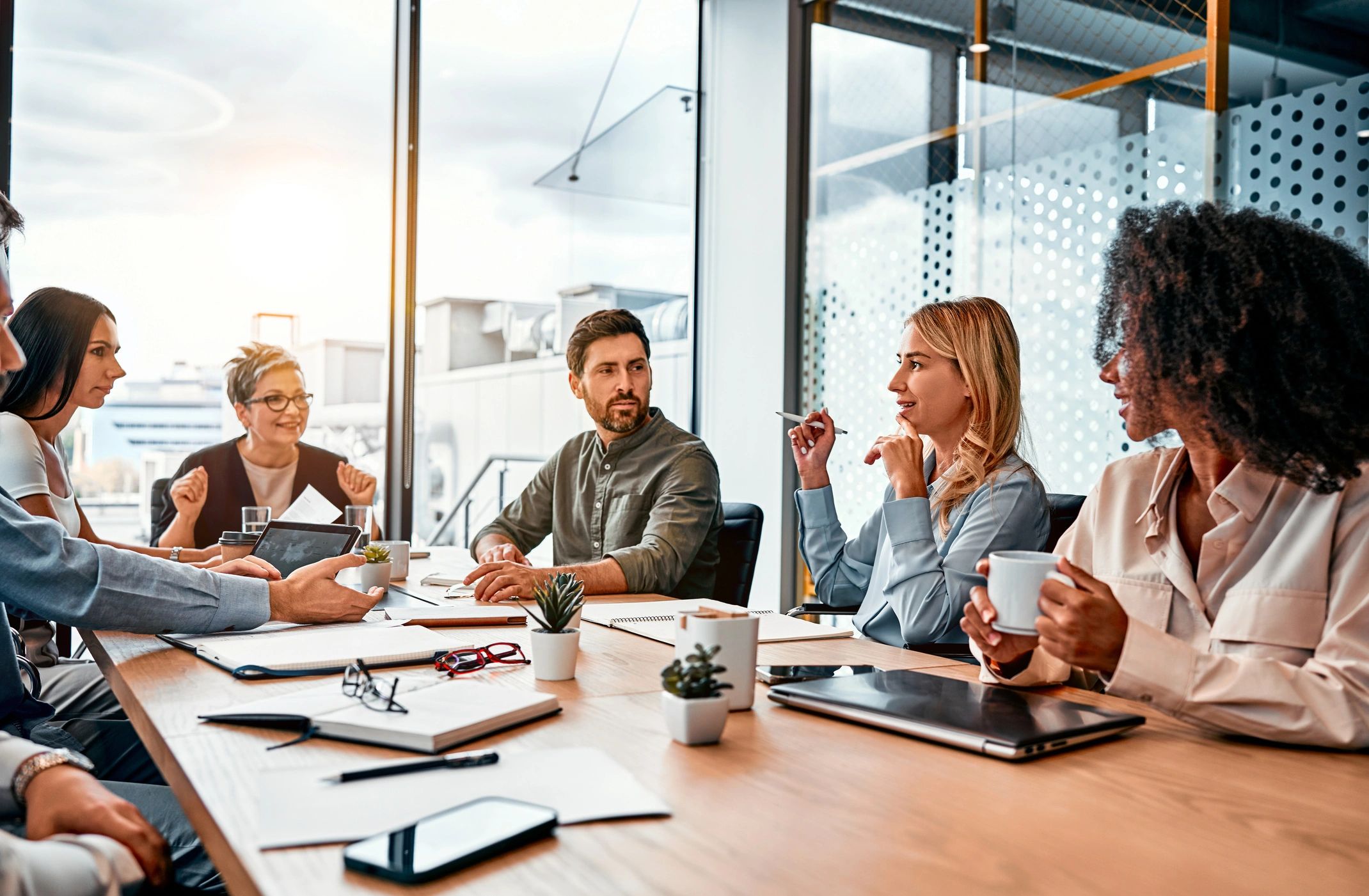 Team meeting with diverse professionals discussing ideas around a conference table.